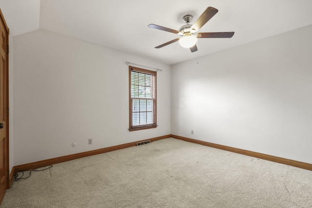 carpeted spare room featuring ceiling fan and lofted ceiling