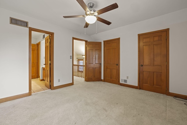 unfurnished bedroom featuring ceiling fan, light colored carpet, and connected bathroom