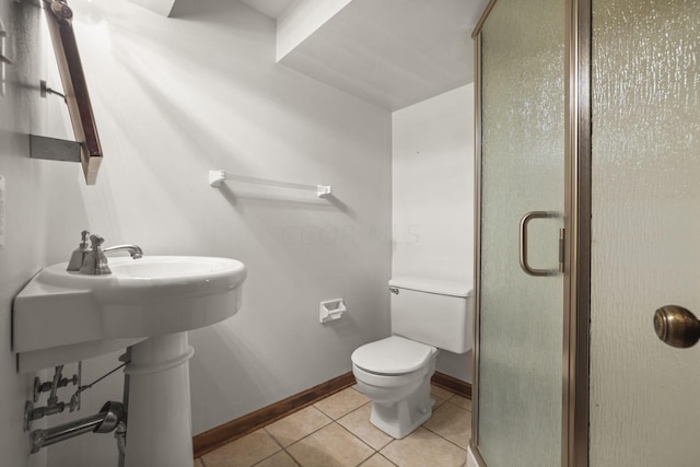 bathroom with tile patterned flooring, toilet, and an enclosed shower