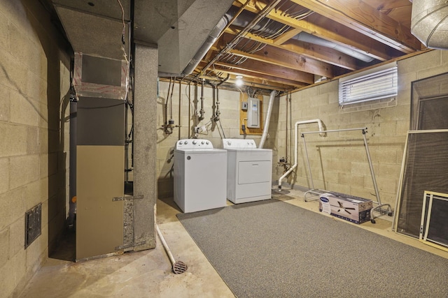 basement featuring washing machine and dryer, electric panel, and heating unit