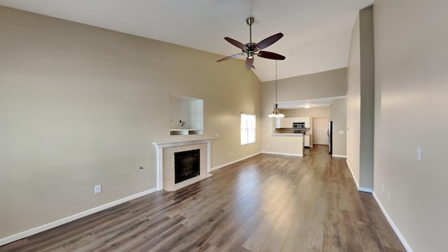 unfurnished living room featuring hardwood / wood-style floors, high vaulted ceiling, and ceiling fan