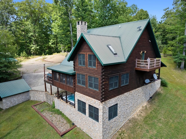 back of property with a lawn and a balcony