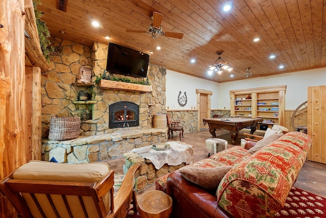 living room with wood ceiling, ceiling fan with notable chandelier, billiards, a fireplace, and wood walls