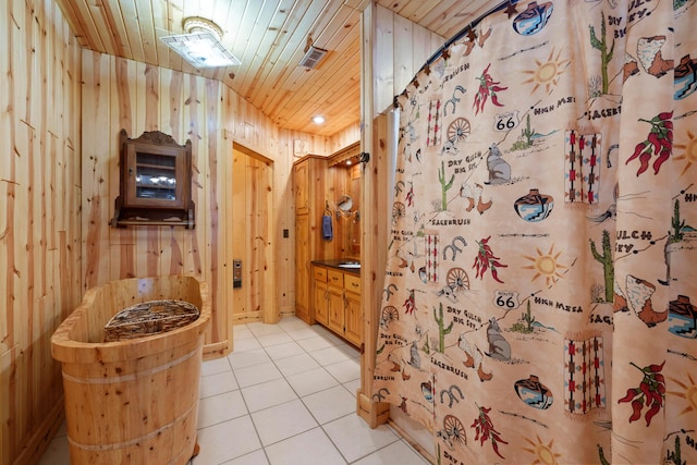 bathroom with tile patterned flooring, vanity, wood walls, and wood ceiling