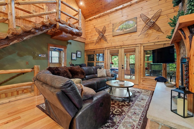 living room featuring hardwood / wood-style floors, a healthy amount of sunlight, high vaulted ceiling, and french doors