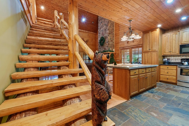 kitchen with log walls, a notable chandelier, backsplash, decorative light fixtures, and stainless steel stove