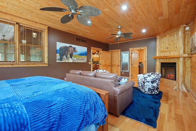 bedroom with a fireplace, light hardwood / wood-style floors, ceiling fan, and wooden ceiling