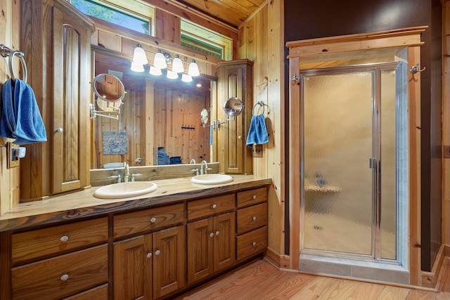 bathroom featuring vanity, hardwood / wood-style flooring, walk in shower, and wood walls