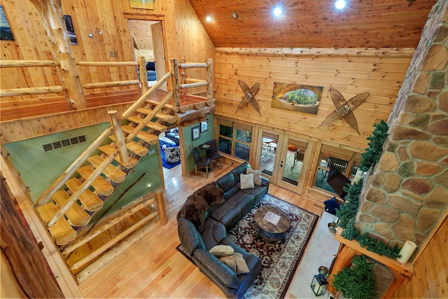 living room with french doors, hardwood / wood-style flooring, high vaulted ceiling, wooden ceiling, and wood walls