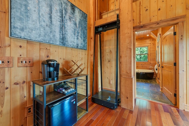 interior space with hardwood / wood-style floors and wooden walls