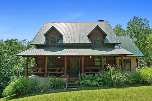 log cabin with covered porch and a front lawn