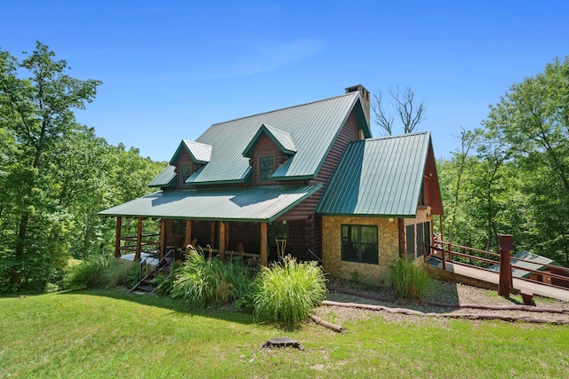 rear view of house featuring a yard and covered porch