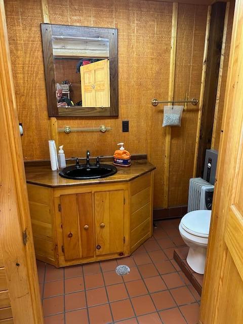 bathroom featuring tile patterned floors, radiator heating unit, vanity, and toilet