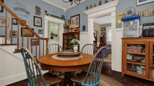 dining space featuring dark hardwood / wood-style flooring, an inviting chandelier, and crown molding