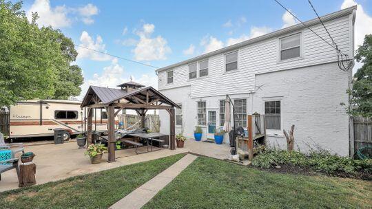 rear view of house featuring a gazebo and a lawn