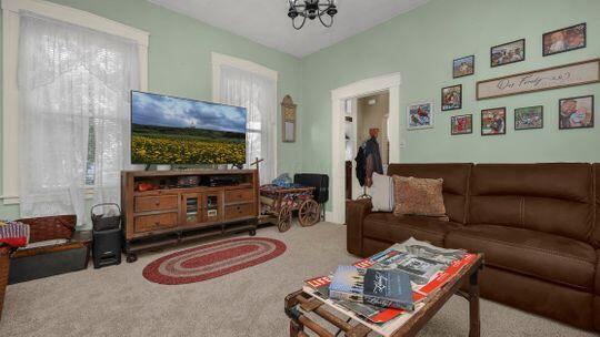 living room with carpet floors and a chandelier