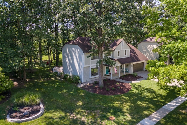 view of front of home featuring an attached garage, driveway, and a front lawn