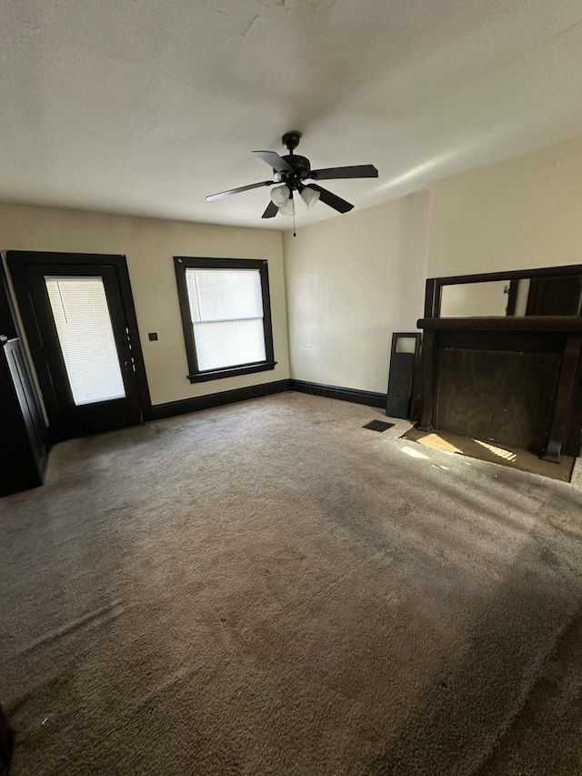 interior space featuring ceiling fan and carpet