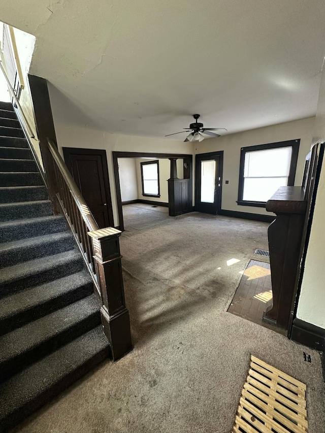 interior space with ceiling fan and carpet