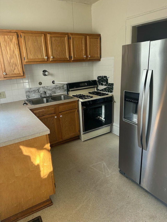 kitchen with stainless steel refrigerator with ice dispenser, sink, backsplash, and gas range oven