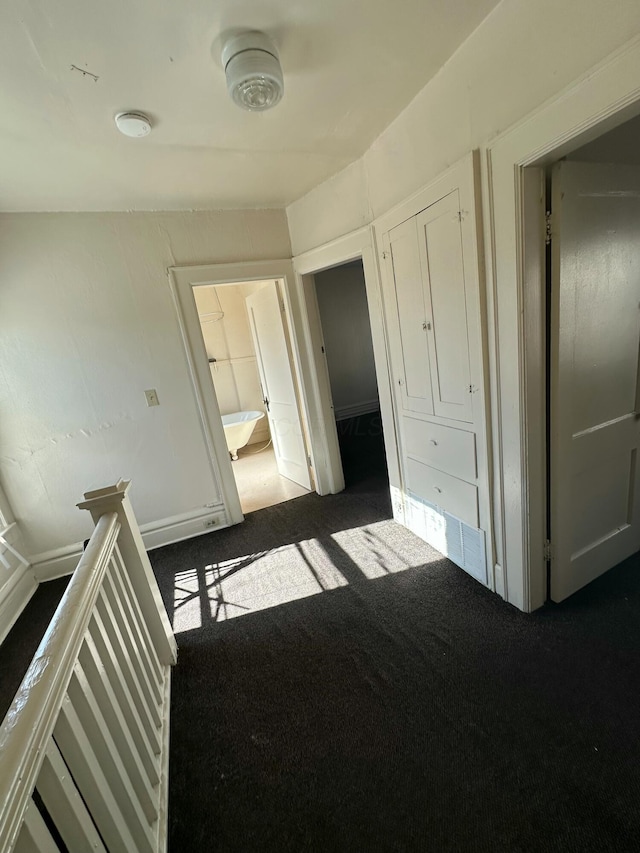 unfurnished bedroom featuring dark colored carpet