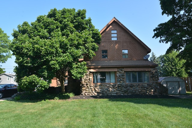 view of front of home featuring a storage shed and a front lawn