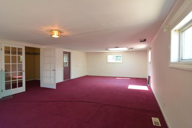 basement featuring crown molding, french doors, carpet floors, and plenty of natural light