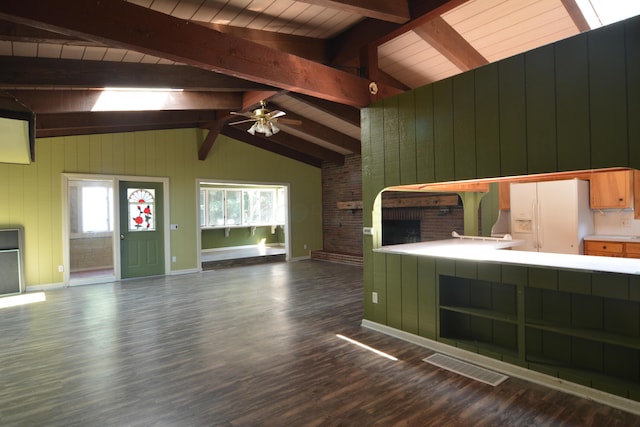 unfurnished living room featuring ceiling fan, wooden walls, dark wood-type flooring, wooden ceiling, and vaulted ceiling with beams