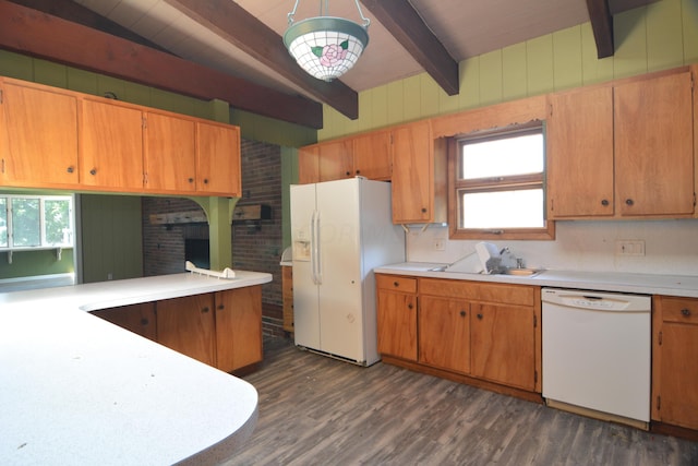 kitchen featuring white appliances, sink, dark hardwood / wood-style floors, beam ceiling, and brick wall