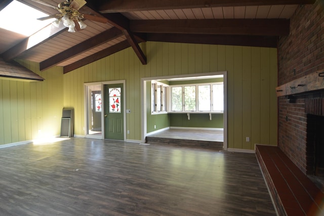 unfurnished living room featuring lofted ceiling with beams, a healthy amount of sunlight, ceiling fan, and dark wood-type flooring