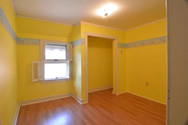 unfurnished room featuring hardwood / wood-style floors and crown molding