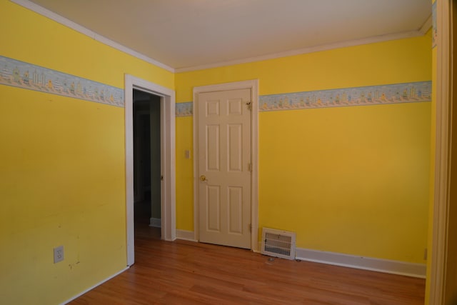 spare room featuring hardwood / wood-style floors and ornamental molding