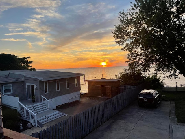 property exterior at dusk with a water view