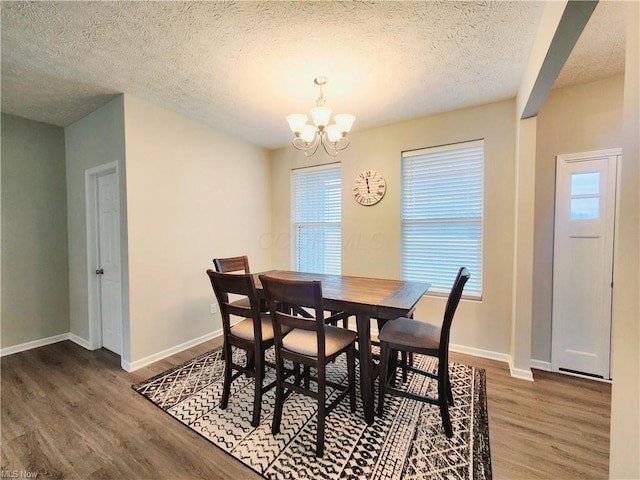 dining room featuring an inviting chandelier, a textured ceiling, and dark hardwood / wood-style flooring