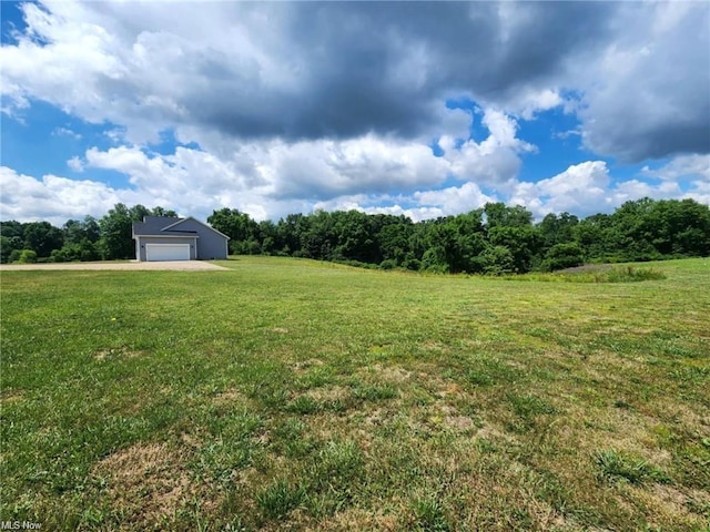 view of yard featuring a garage and a rural view