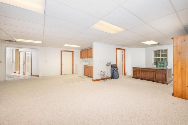 basement featuring light carpet and a drop ceiling