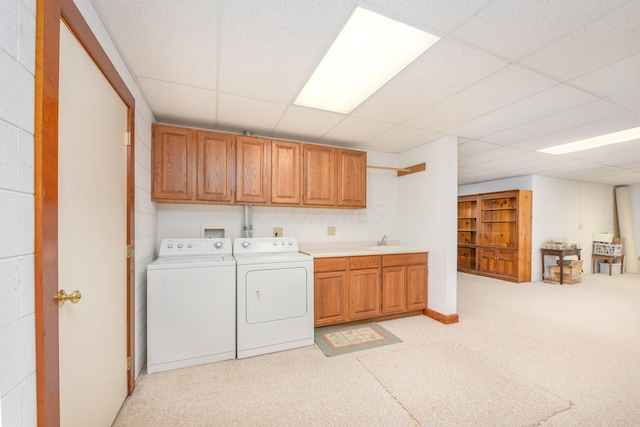 clothes washing area with cabinets, independent washer and dryer, and sink