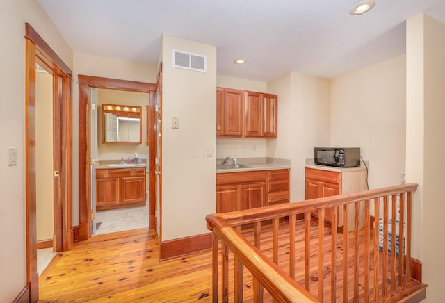 hallway with light hardwood / wood-style floors and sink