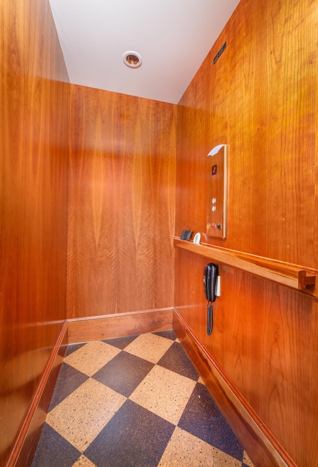 interior space with elevator and wooden walls