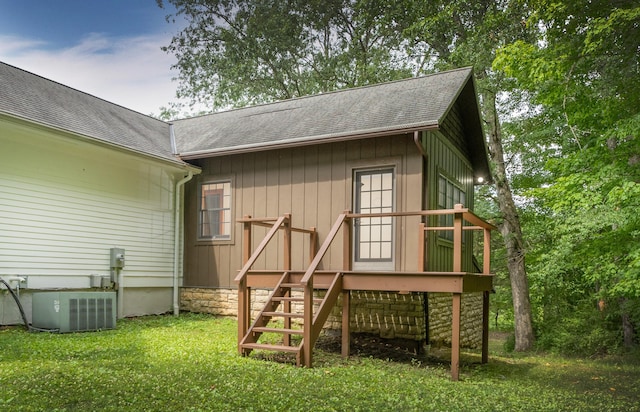 exterior space with a yard, central AC unit, and a deck