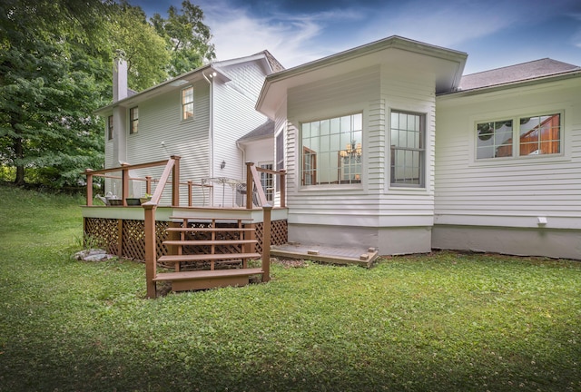 rear view of house with a lawn and a deck