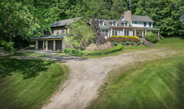 view of front facade featuring covered porch, a garage, and a front yard