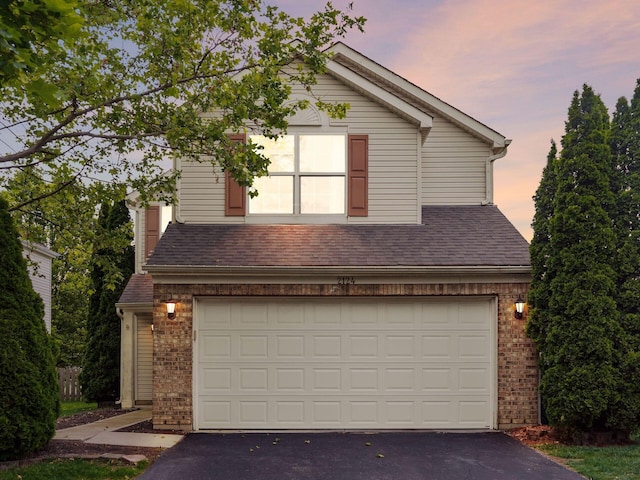 2124 Ripple Rd, Hilliard, OH 43026 - traditional home featuring brick siding, asphalt driveway, a garage, and a shingled roof