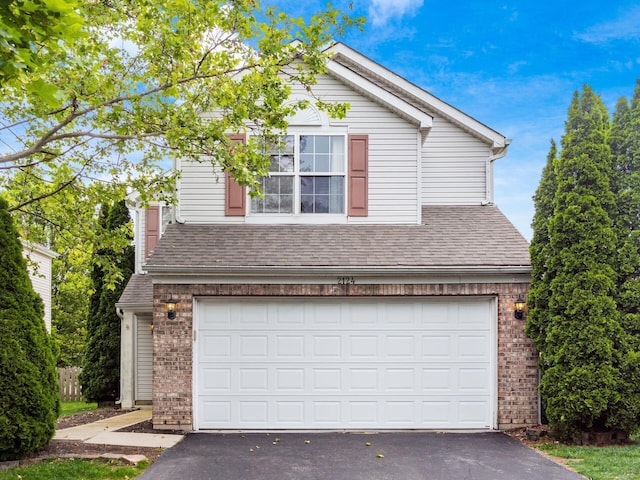 2124 Ripple Rd, Hilliard, OH 43026 - view of front of home with driveway, brick siding, a garage, and roof with shingles