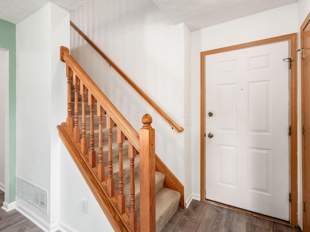 2124 Ripple Rd, Hilliard, OH 43026 - foyer entrance with dark wood-style floors, baseboards, stairs, and a textured ceiling