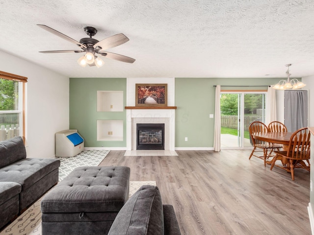 2124 Ripple Rd, Hilliard, OH 43026 - living area featuring wood finished floors, plenty of natural light, a chandelier, a textured ceiling, and a fireplace with flush hearth