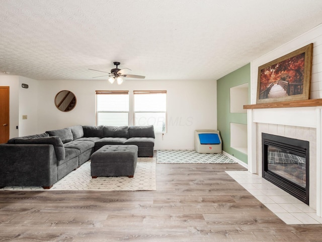 2124 Ripple Rd, Hilliard, OH 43026 - living room with a fireplace, wood finished floors, a textured ceiling, and ceiling fan