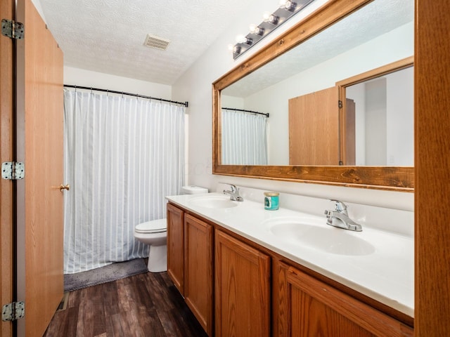 2124 Ripple Rd, Hilliard, OH 43026 - bathroom with wood finished floors, double vanity, toilet, and a textured ceiling