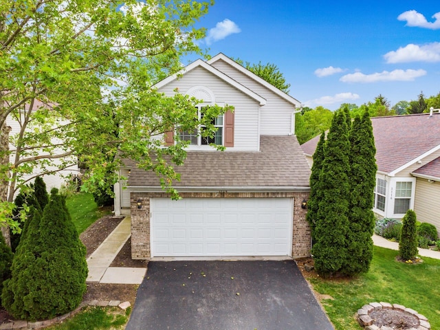 2124 Ripple Rd, Hilliard, OH 43026 - view of front facade featuring brick siding, asphalt driveway, an attached garage, roof with shingles, and a front yard