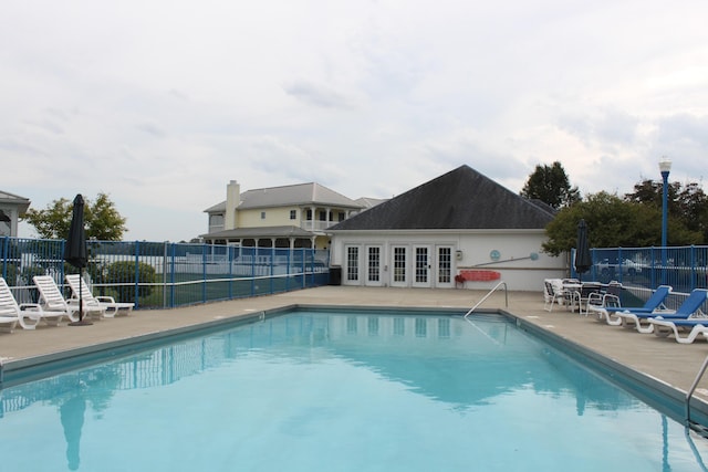 view of swimming pool with french doors and a patio area